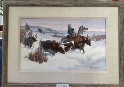 A framed painting of longhorn cattle driven through snow by a mounted cowboy