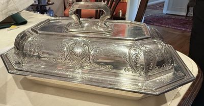 A sterling silver covered entree dish with a chased lid and detachable handle