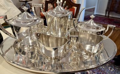 A sterling silver coffee and tea service with creamer and covered sugar, arranged on an oval tray