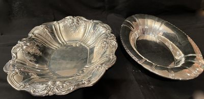 A sterling silver repousse bowl beside a plainer oval vegetable dish