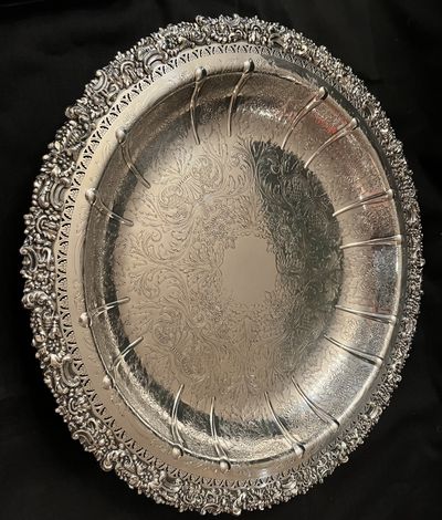 A sterling silver plate with an engraved centre and a cast openwork border