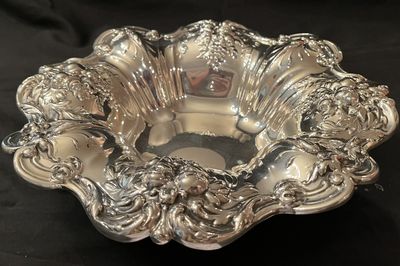 A sterling silver bowl with a deep repousse border of fruit and scrollwork