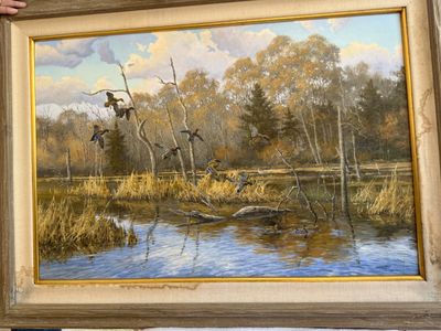 A framed oil painting of ducks rising over a marsh in autumn